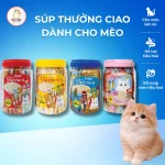 Hộp Ciao Churu mix vị bên cạnh mèo đang chờ ăn thưởng