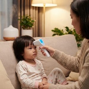 Người dùng đo nhiệt độ bằng nhiệt kế hồng ngoại không tiếp xúc tại nhà